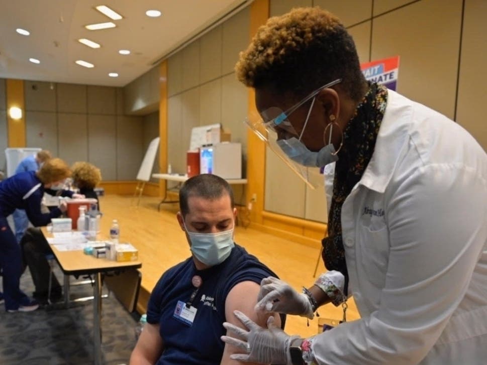 An employee at Abington Hospital receives an early dose of the new Pfizer coronavirus vaccine. He's one of more than 5,000 who have received doses countywide.