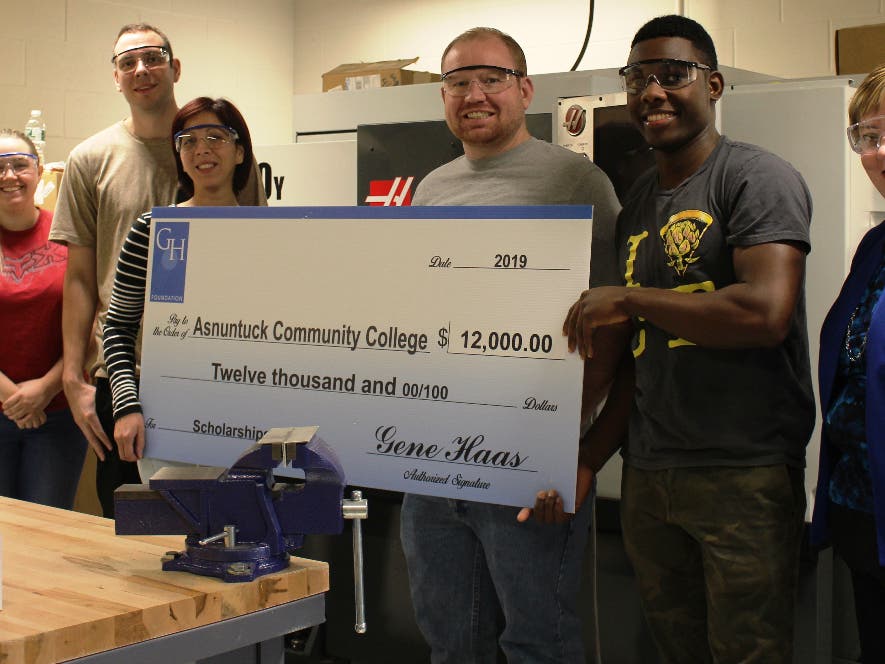 Asnuntuck Advisor Kellie Payne, Asnuntuck students Shianne Cannizzaro, David Kalman, Jessica Velazquez, William Fox, Kimani Rattray and Interim Dean of Asnuntuck’s Advanced Manufacturing Technology program hold a check from The Gene Haas Foundation. 