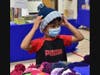  Trying on the cool hats handmade by community members at the 2022 Back to School Shop 