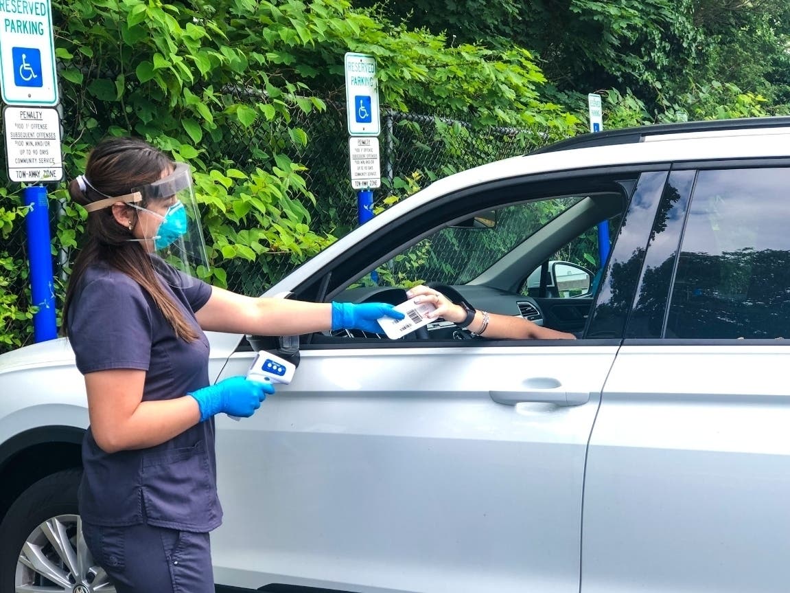 VNA Certified Medical Assistant Ali Robles provides a COVID-19 test kit to a local resident at the Red Bank Family YMCA, now a site for testing three days a week by the Visiting Nurse Association of Central Jersey Community Health Center.