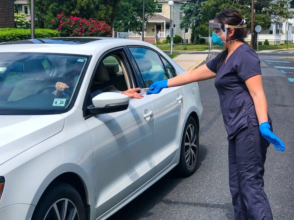 VNA Certified Medical Assistant Ali Robles provides a COVID-19 test kit to a local resident at the Red Bank Family YMCA, now a site for testing three days a week by the Visiting Nurse Association of Central Jersey Community Health Center.