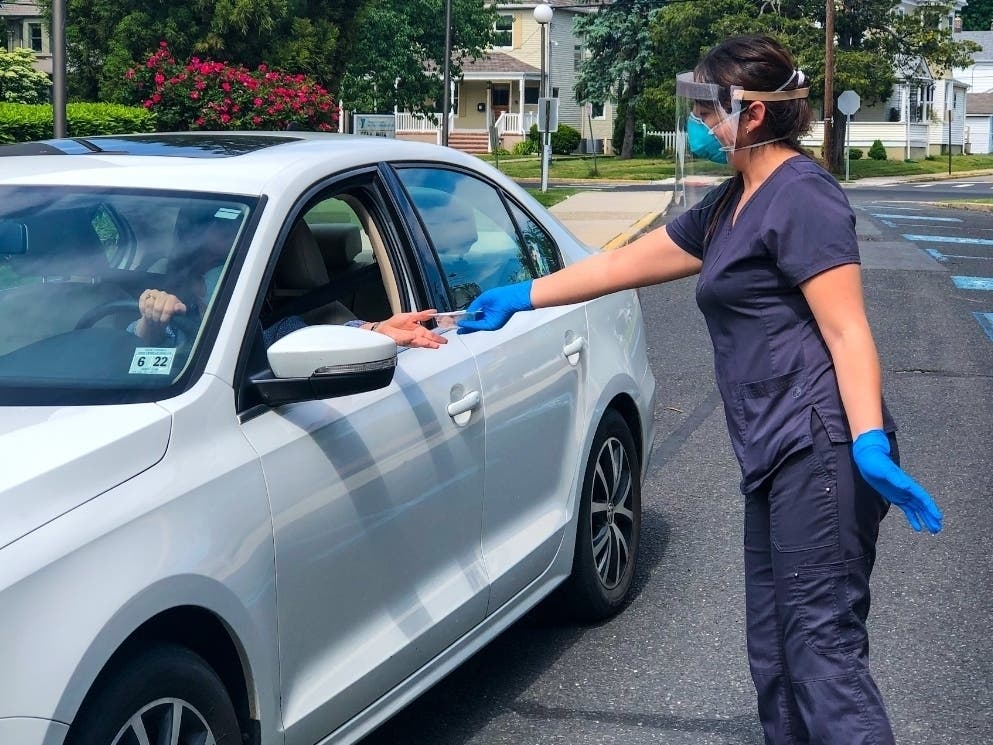 VNA Certified Medical Assistant Ali Robles provides a COVID-19 test kit to a local resident at the Red Bank Family YMCA, now a site for testing three days a week by the Visiting Nurse Association of Central Jersey Community Health Center.