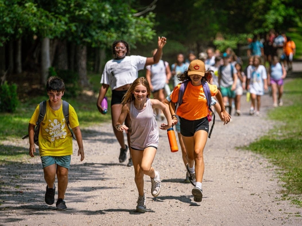 Children of all ages charge toward a day of fun at YMCA Camp Zehnder.