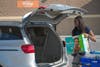 A Walmart associate loads groceries into a customer's car