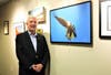Donald Roland of Annapolis poses with his piece, “Diving Eagle,” during the Digital Photography Club of Annapolis artist