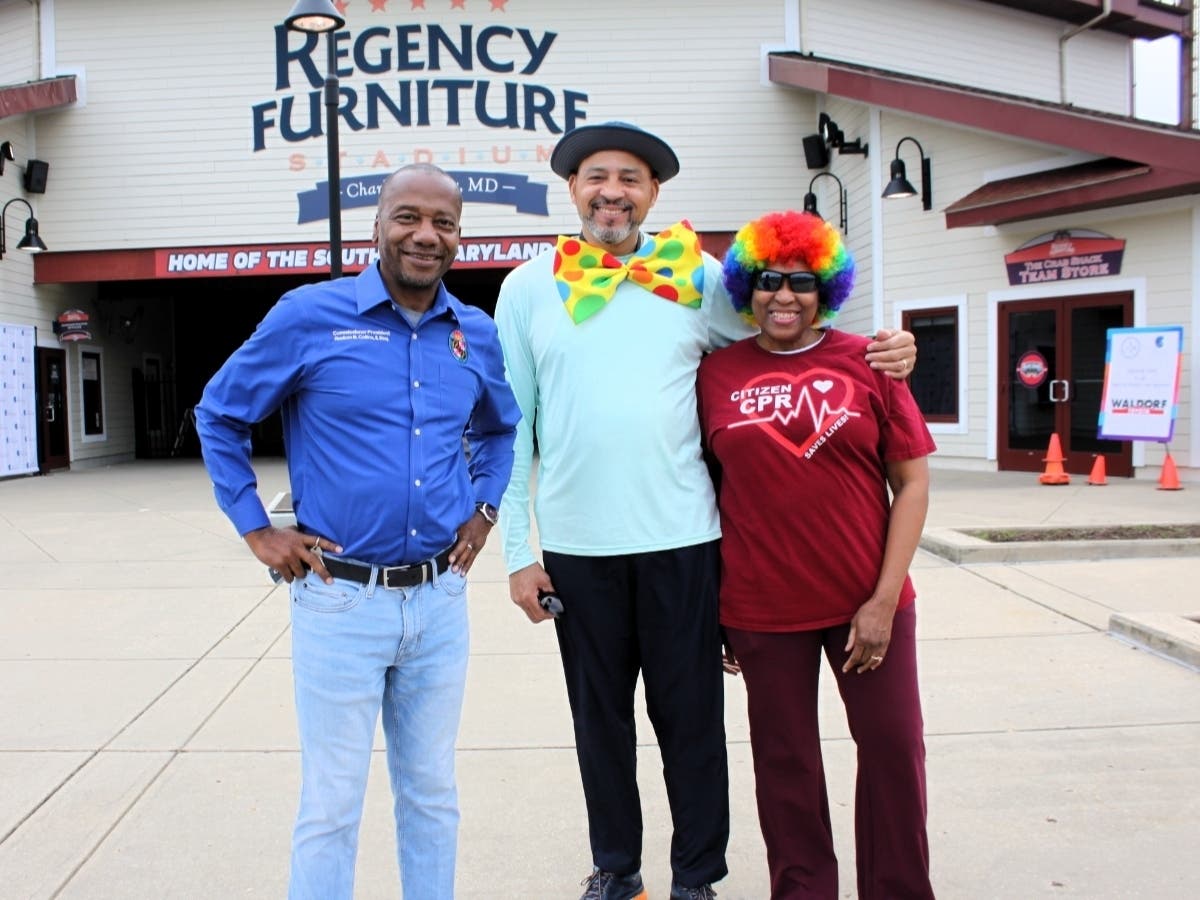 Reuben B. Collins, II, Esq., President of the Charles County Board of Commissioners, stands with Hospice of the Chesapeake volunteers Elton and Sibyl Wright of Upper Marlboro before the start of the race. Collins was the event’s Grand Marshal.