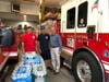 Middletown volunteer fire fighters with IMA’s Dr. John Haddad and some of the donated water.