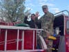 Brie and Matthew Zilinski ride on a Middletown Twp. firetruck Saturday during the surprise homecoming parade.