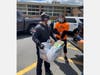 Michael Lombardi helps an Edison resident unload non-perishable food donations from a pickup truck.