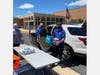 Volunteers unload non-perishable food from an SUV outside Edison High School.