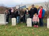 The group of volunteers stand by Dennis Zilinski's grave at West Point.