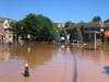 Flood waters pour through a riverfront housing complex in New Brunswick after Tropical Storm Ida on Sept. 2, 2021. That's a man standing on top of a floating car, red.
