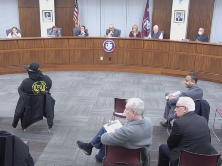 A member of the Proud Boys, in all black, at left at the Feb. 15 Woodbridge Council meeting. U.S. Congress candidate Rik Mehta, who is unaffiliated with the Proud Boys, was also at the meeting, at right. Mehta, a Republican, recently moved to Woodbridge.