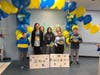 Elizabeth Kryvulko, center, in black, surrounded by her new classmates at Monmouth Beach Elementary. The signs say "welcome to our school."