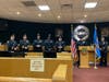 From left: Secaucus Deputy Chief Joe Baccola, Police Chief Dennis Miller, Mikhail Kowlesser and Jude Masullo listen as Officer/Secaucus Police PBA President Michael Borrelli speaks at the podium.