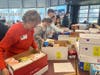 Dennis' mother, Marion Zilinski, in orange, helps pack the care packages.