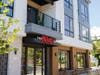 The main entrance to the new condo building, with coffee shop seating outside.
