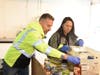 New York & Atlantic President James Bonner and Marketing Support Manager Amy Louk sort food in Hauppauge