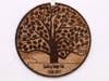 A round wooden ornament that has been laser etched with a rendering of the tree in bloom.