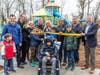 Adults and kids participate in cutting the ribbon at the new Raymond Willis Brown Playground at Duke Island Park in Bridgewater.