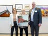 First Place Artist Barbara A. Friedman holds her painting of Beechtree Farm (Montgomery) with Commissioners Melonie Marano and Paul Drake.