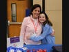 Franklin Elementary School mother and daughter volunteers share a hug as they assist during Community Service Night.