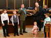 Officer Michael Thomsen with his family being sworn in by Council President Timothy Ring.