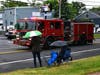 Two spectators braved the weather with open umbrellas as the North Branch Fire truck passed by.
