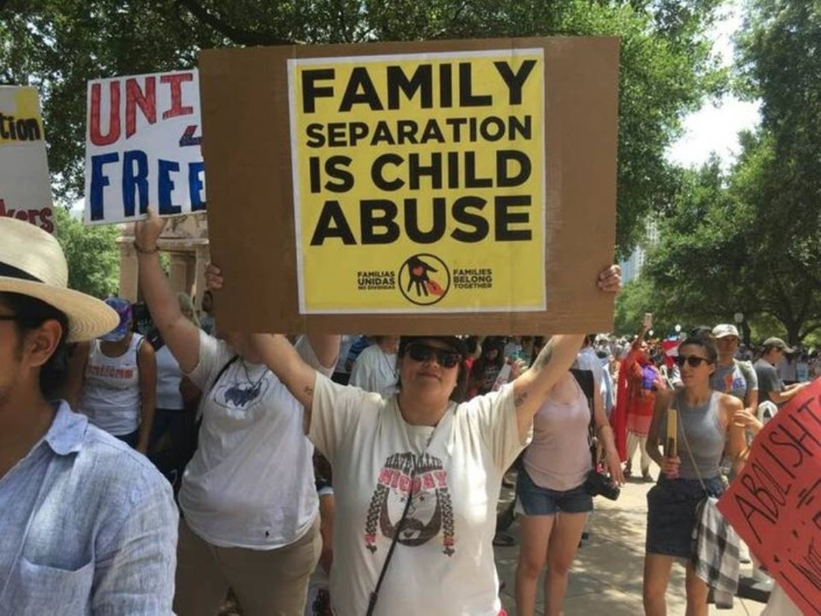 Woman protests Trump's zero-tolerance immigration policy marked by separation of migrant families crossing the border.