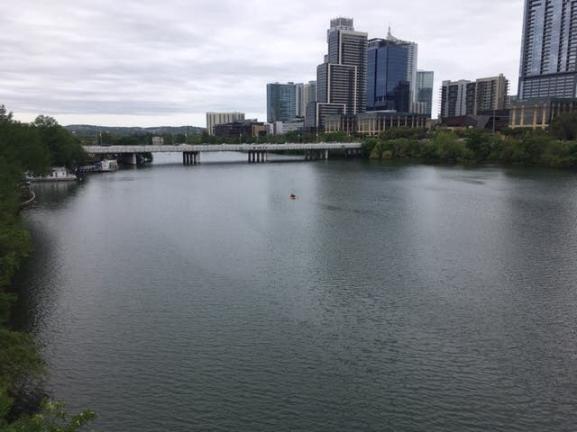 Lone kayaker floats across Lady Bird Lake running through the middle of the city on March 30, 2019.