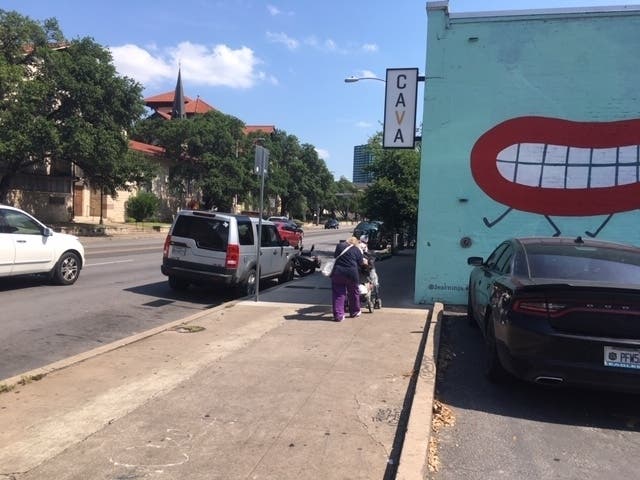 With a heat index of 111 degrees on Sunday, June 9, elderly homeless woman pushes her cart along Guadalupe Street.