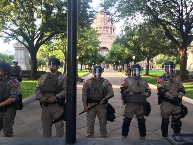 Police stand guard outside the gates of the Texas Capitol amid protests against law enforcement abuse on May 30, 2020.
