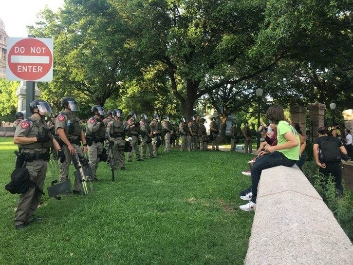 Young protesters square off against police troops after a day of protests in Austin on May 30, 2020.