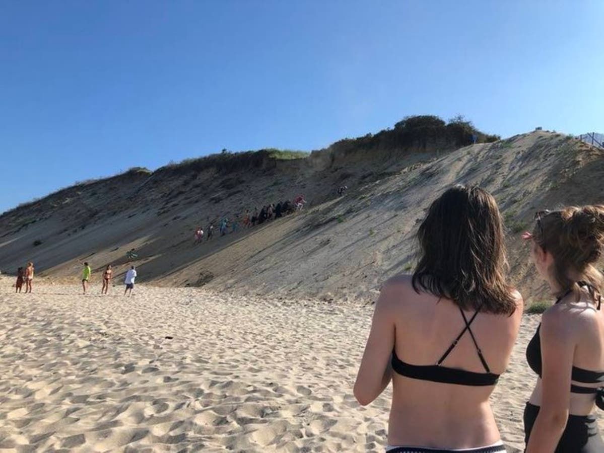  Beachgoers help carry shark bite victim William Lytton up Long Nook Beach in August 2018.