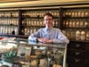 New Canaan Historical Society Librarian Archivist Michael Murphy stands behind a display case at the Cody Drug Store.