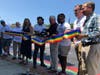 Mayor Harry Rilling cuts a rainbow ribbon during the unveiling of a new rainbow crosswalk in Norwalk on Tuesday.