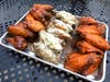 A plate of spicy buffalo, garlic parmesan and plum sriracha wings at The Blind Rhino in Norwalk.