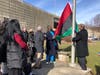 The Pan-African flag is raised during a ceremony Tuesday afternoon in Norwalk.