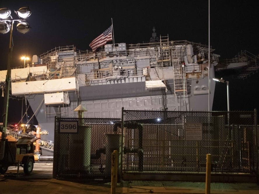 The America flag flies aboard the amphibious assault ship USS Bonhomme Richard (LHD 6) as damage control efforts continue on board. 