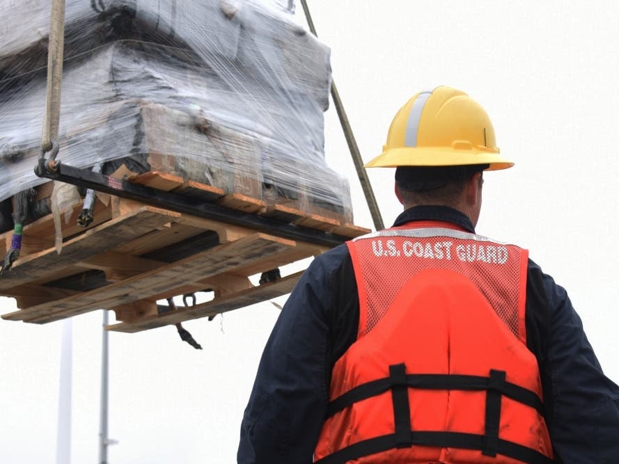 The crew of the Coast Guard Cutter Active offloads approximately 11,500 pounds of seized cocaine in San Diego, Wednesday. The drugs, worth an estimated $220 million, were seized in international waters of the Eastern Pacific Ocean during April and May.