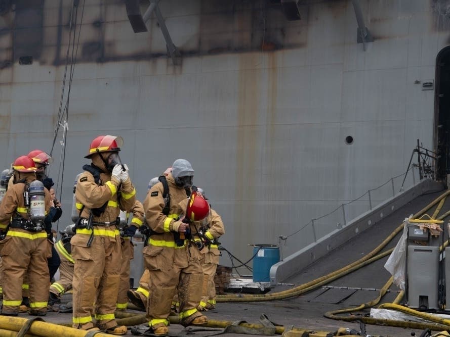 Sailors and Federal San Diego Firefighters equip gear before providing firefighting assistance on board USS Bonhomme Richard (LHD 6) on the morning of July 13.