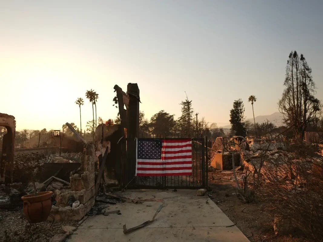 An American flag hangs on the gate of a home destroyed by the Eaton Fire in Altadena, Calif., Jan. 10, 2025.
