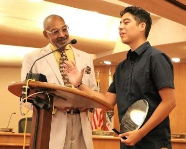 Mentor Dan Daniels (left) listens to Benjamin Magana during the Career Explorers graduation ceremony last year.