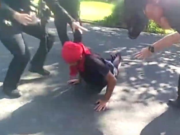 Walnut Creek Police officers reaching out for Miles Hall after his was shot by officers.