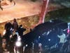 Protesters surround an SUV, holding the occupants prisoner and trying to open the driver's door.