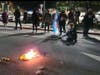 A flag is burned on a downtown Walnut Creek street Saturday night.