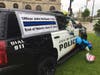 A squad car is decorated with numerous tributes to fallen officer John Hetland. 