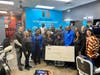 Grand prize winner and Southfield barbershop owner Dawn Sandford seated center, left of Justin Kimpson, Ford Fund, with community partners and barbershop staff.