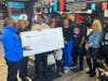 Grand prize winner and Detroit barbershop owner Duane Greathouse, standing center front, as Justin Kimpson, Ford Fund, congratulates him with a check.