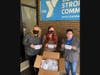 Kathy Fielding, North Suburban YMCA CEO, Tara Wesselink, North Suburban YMCA’s Social Responsibility & Sustainability Coordinator, and Tabitha Nelson, In-Kind Program Donations Supervisor for the WINGS Program display the Y’s  mask donation.